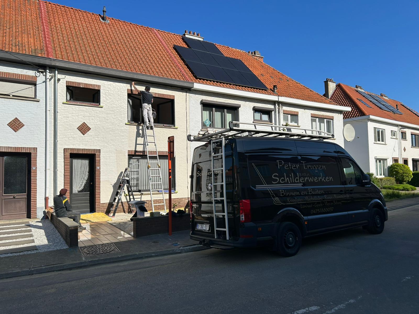 Schilder op ladder werkt aan een gevel, bedrijfswagen van Peter Truyen Schilderwerken op de voorgrond